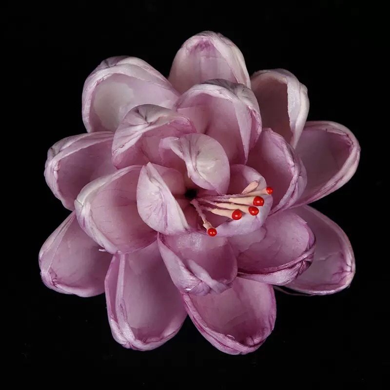 Purple colored paper lotus artificial flower macro shot highlighting vibrant dye and texture