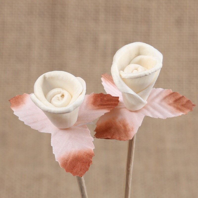 Macro shot of 3cm handmade Tong Cao rose dried flower, showcasing delicate petal texture and natural vine stem attachment.