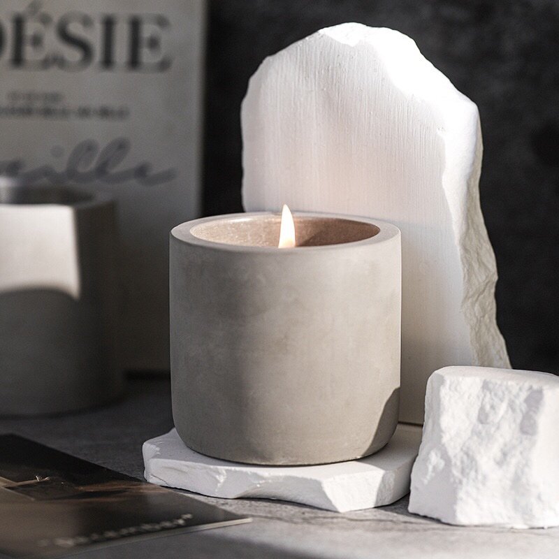 Set of four earth gray cement candle cups in different sizes, with one showcasing the optional lid.