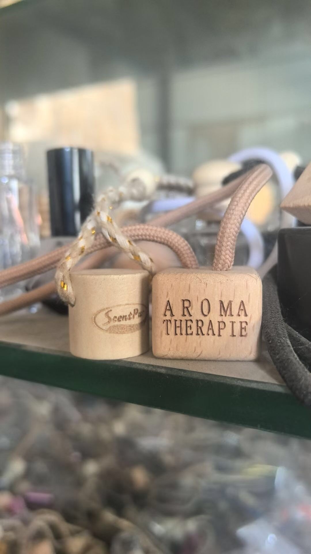 Two different wood lids for car diffuser bottles, each with a laser engraved logo – custom branding for aromatherapy products.