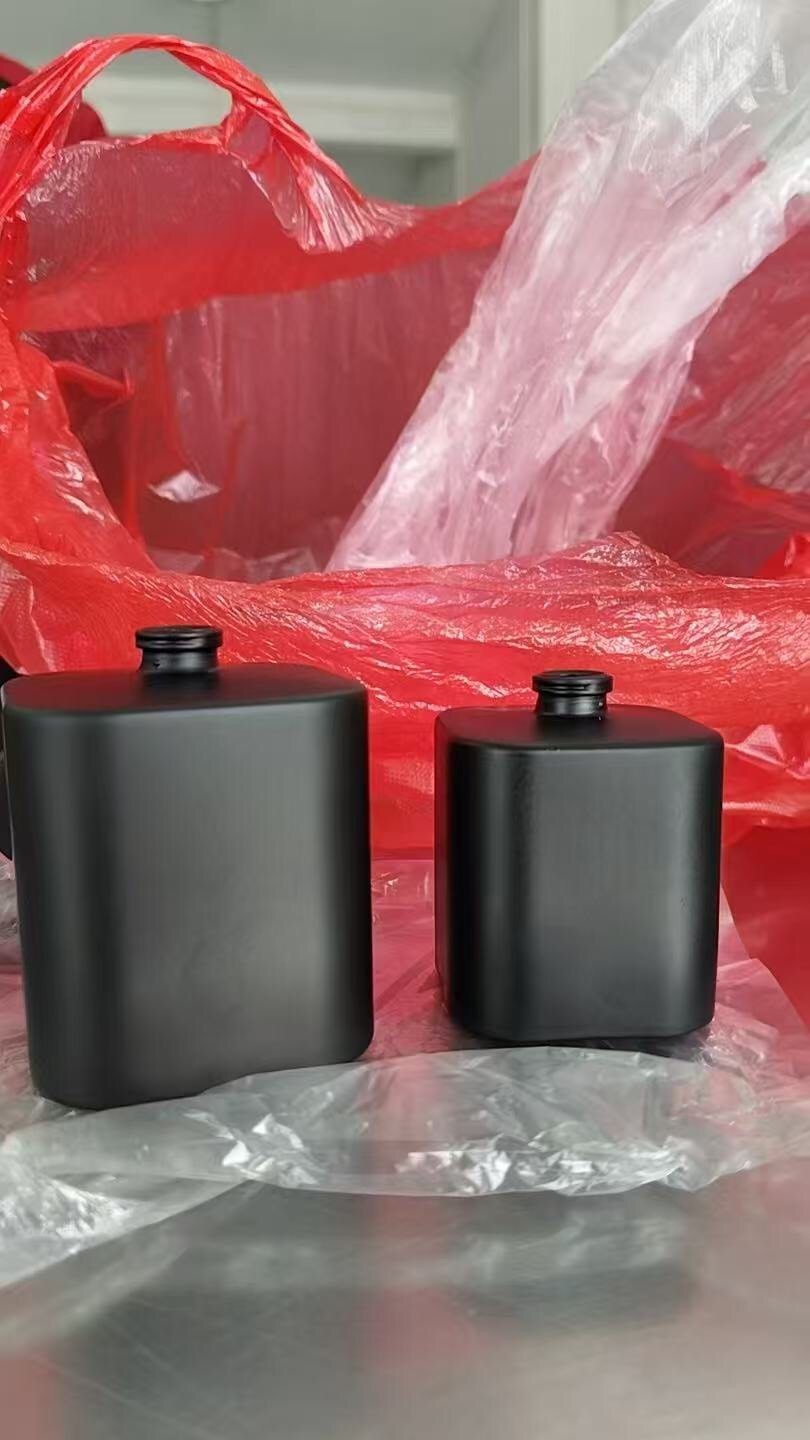 Matte black sprayed perfume bottles, 50ml and 100ml, after custom color finishing