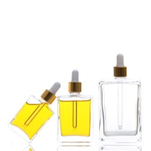 Three flat square dropper bottles filled with essential oil – 30ml, 50ml, 100ml – amber or colored liquid visible