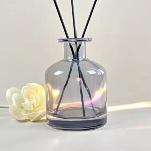 Gray transparent aromatherapy bottle from side view – rattan sticks inserted, showing liquid level and subtle gray tint
