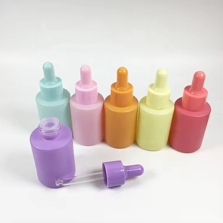 Close-up of 30ml solid color essential oil bottles – vibrant purple, green, blue, pink, orange, yellow, red standing in rows