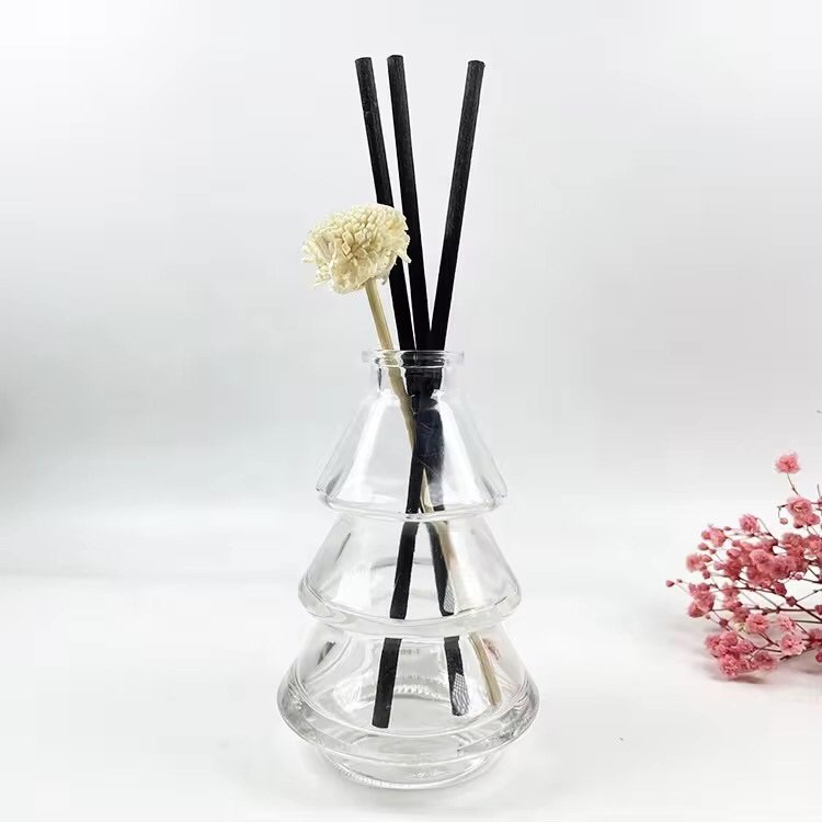 Christmas tree shaped aromatherapy bottle used as reed diffuser – rattan sticks and dried flowers inserted, natural home fragrance setup