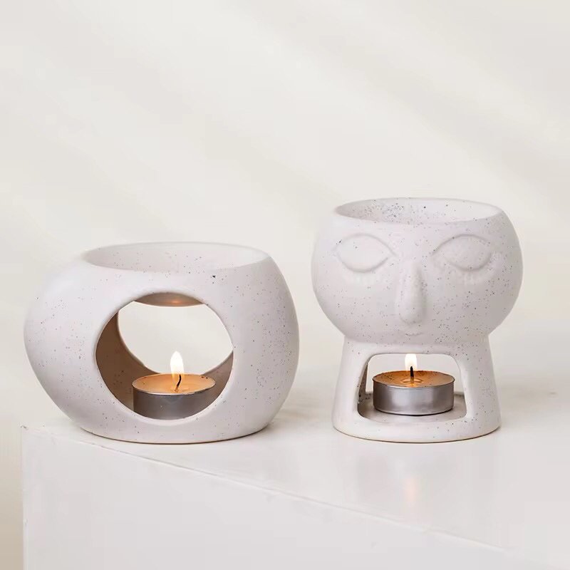 Two different sculptural white ceramic wax melt burners placed side by side – abstract shapes, clean lines