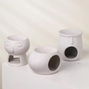 Three white ceramic wax melt burners in three distinct sculptural forms – complete collection, grouped on a neutral surface