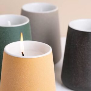 Close-up of yellow, green, gray, and black Nordic jars – side by side, showing matte texture and color contrast