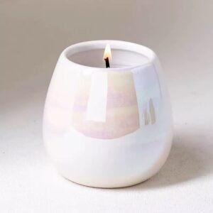 Rainbow pearl glaze ceramic candle jar with a lit candle – iridescent pink, blue, gold reflections, cozy glow