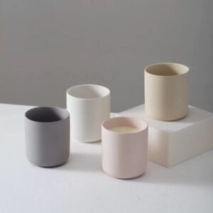 Four solid color ceramic jars – matte white, matte gray, matte pink, matte beige – front row display